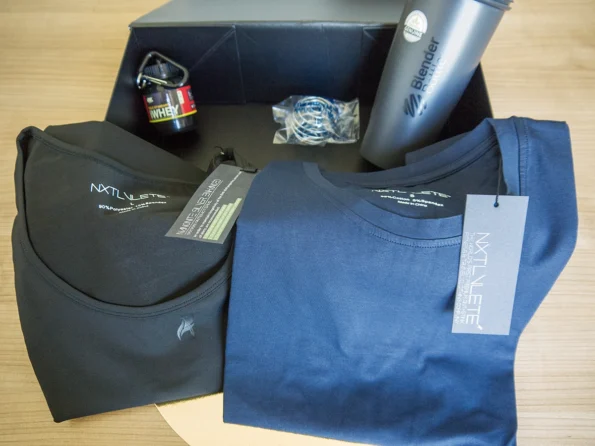 FITmas Box in size M includes: Shirt, Tank Top, BlenderBottle Classic, protein powder storage container